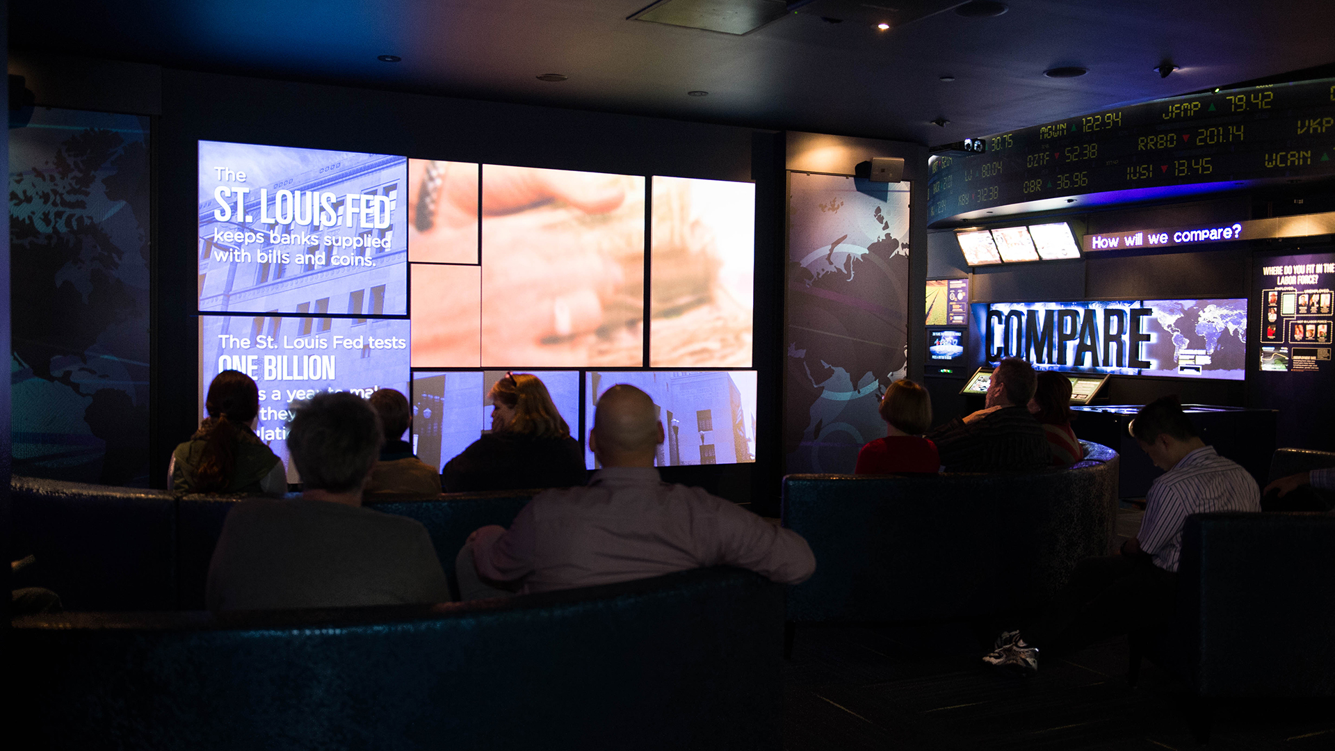 A group of people watch a video in a dark theater.
