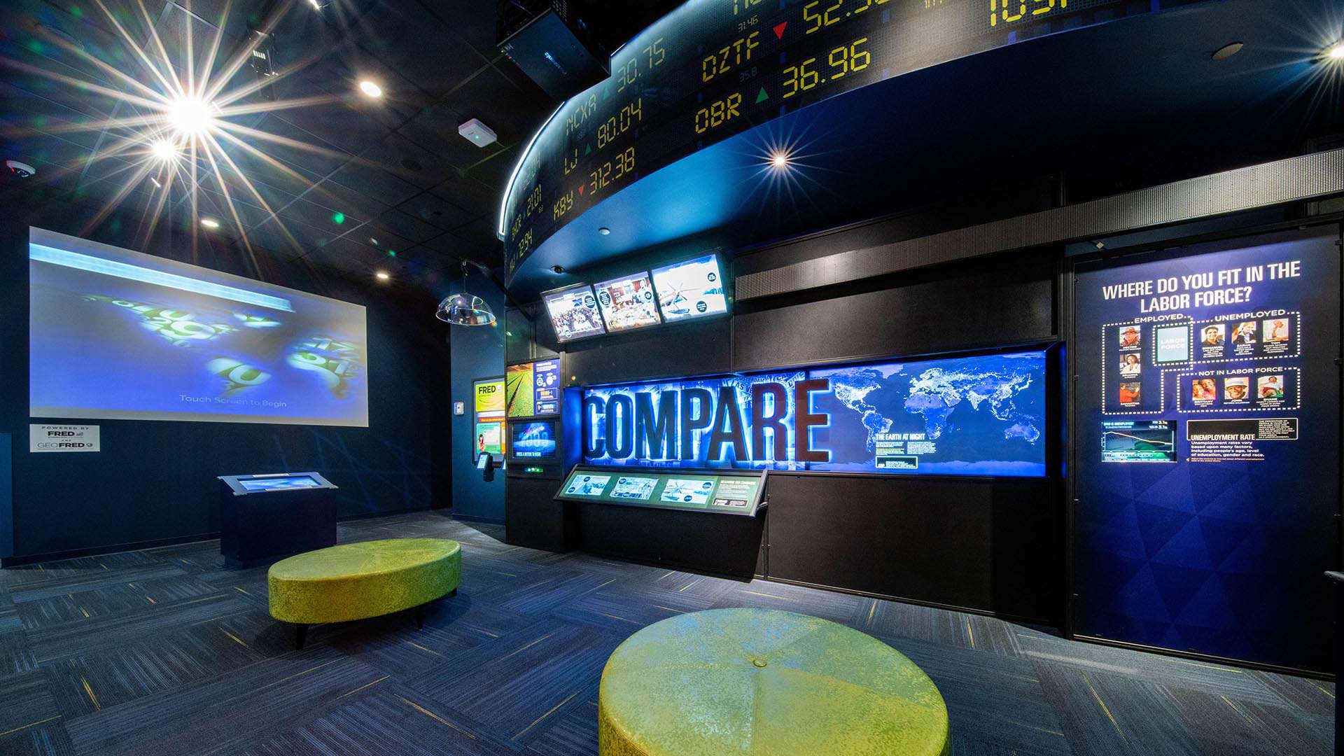 Digital displays line the walls. A large sign that reads "Compare" is in the middle. 
