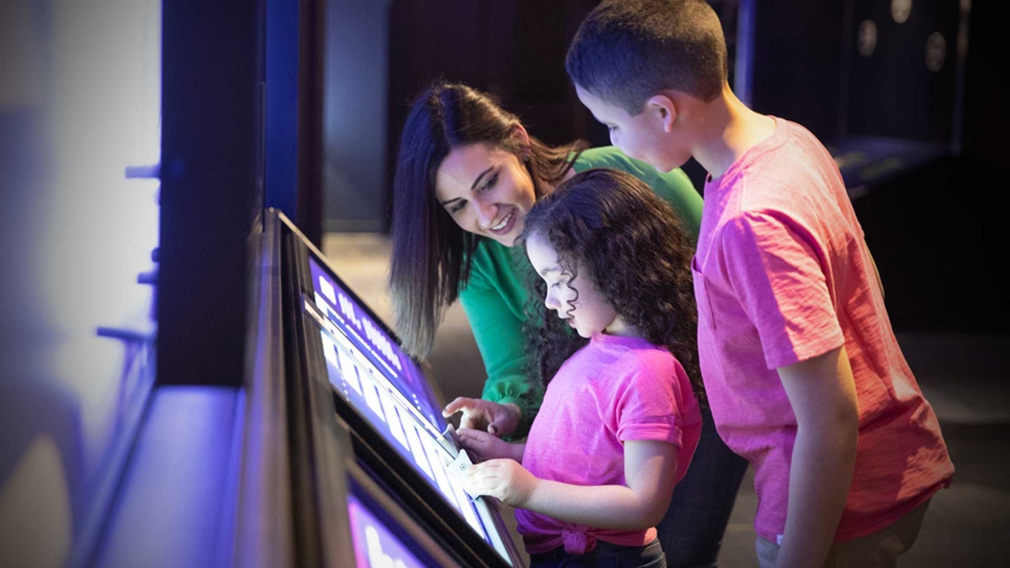 Mother and her kids looking at an interactive exhibit